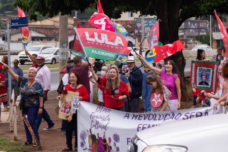 Foto de Varias personas en acción en la calle con banderas rojas de Lula. Imagen hecha en un acto para pedir votos para Lula. - Imagen libre de derechos