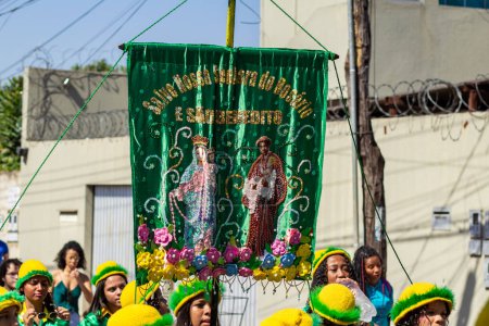 Foto de Un grupo de niñas vestidas con ropa verde, llevando una pancarta durante las Congadas en Goiania, un evento cultural y religioso afrobrasileño. - Imagen libre de derechos