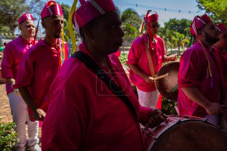 Foto de Un grupo de juerguistas tocando instrumentos de percusión y vestidos de rojo durante Congadas, un festival religioso con elementos de tradiciones tribales de Angola y Congo. - Imagen libre de derechos