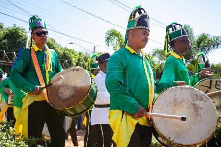 Foto de Unos juerguistas vestidos de verde, tocando instrumentos de percusión durante el desfile de Congadas de Goiania. - Imagen libre de derechos