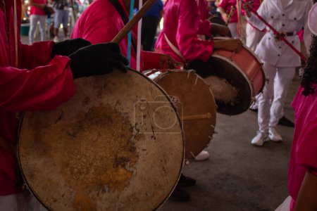 Foto de Unos juerguistas vestidos de rojo con sus instrumentos de percusión, se preparan para iniciar la procesión en Congadas de Goiania. - Imagen libre de derechos