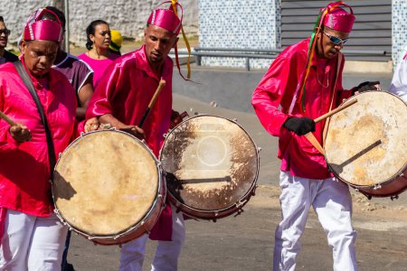 Foto de Reveladores en ropas rojas, bailando y tocando instrumentos de percusión durante las Congadas, un festival religioso con elementos de tradiciones tribales de Angola y Congo. - Imagen libre de derechos