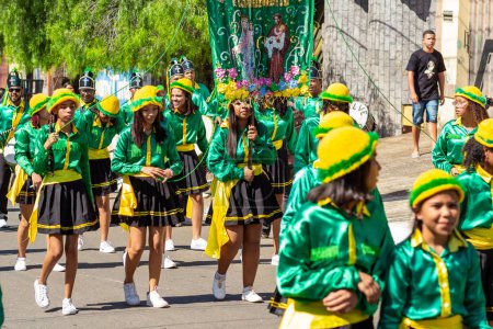 Foto de Un grupo de niñas vestidas con ropa verde, llevando una pancarta durante las Congadas en Goiania, un evento cultural y religioso afrobrasileño. - Imagen libre de derechos