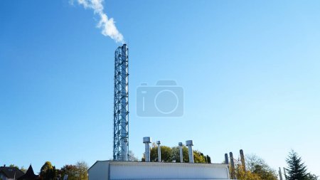 Photo for White smoke from the industrial pipe of the boiler room. Heating the house in winter. Heating with wood - Royalty Free Image