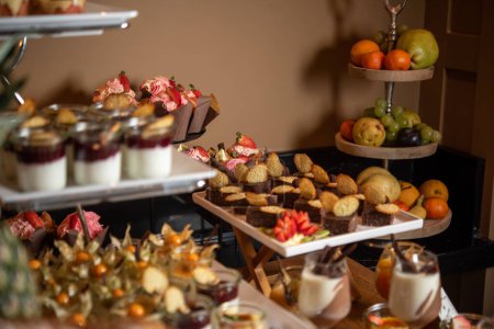 Téléchargez les photos : Desserts décorés avec chocolat et fruits servis sur des stands de gâteaux - en image libre de droit