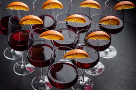 Photo for Closeup shot of red wine served in glasses with orange wedges - Royalty Free Image