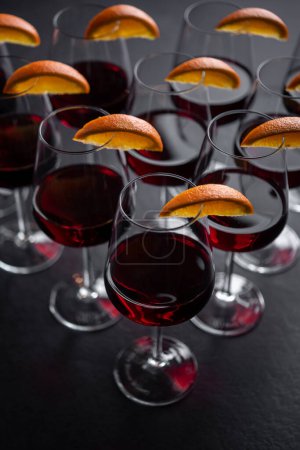 Téléchargez les photos : Gros plan de vin rouge servi dans des verres avec des quartiers d'orange - en image libre de droit