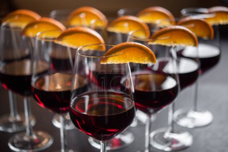 Téléchargez les photos : Vin rouge servi dans des verres avec des quartiers d'orange - en image libre de droit
