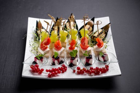 Photo for Canapes with cheese, currants, cherry tomatoes, grapes and eggplants - Royalty Free Image