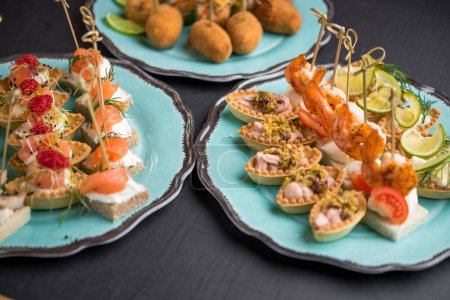 Photo for Variety of gourmet seafood appetizers served on blue plates - Royalty Free Image