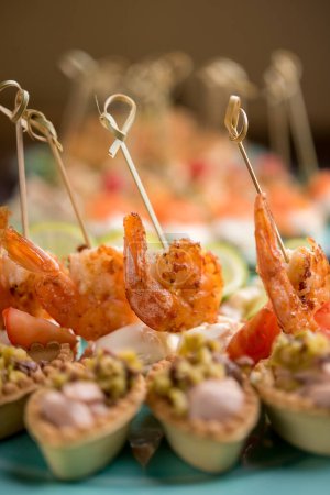 Téléchargez les photos : Délicieuses canapés de fruits de mer aux crevettes, poulpes, fromages et câpres - en image libre de droit