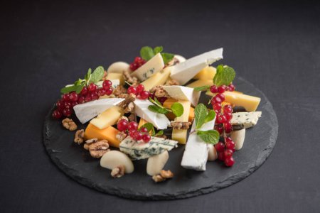 Photo for Cheese platter with red currants and nuts - Royalty Free Image