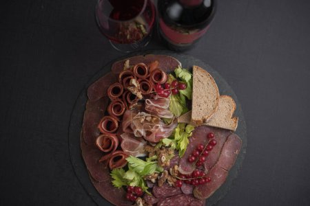 Téléchargez les photos : Elégant plateau de viande salée servi avec du vin rouge - en image libre de droit
