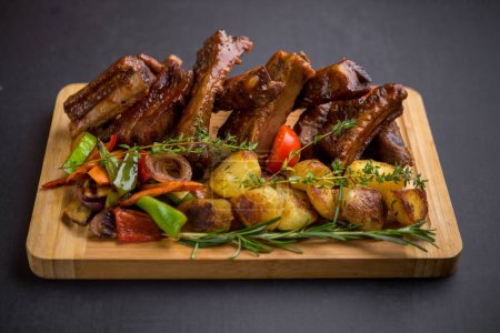 Photo for Ribs barbecue with potatoes, herbs and mixed grilled vegetables - Royalty Free Image