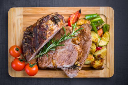 Photo for Baked pork complimented with mixed grilled vegetables and fresh cherry tomatoes - Royalty Free Image