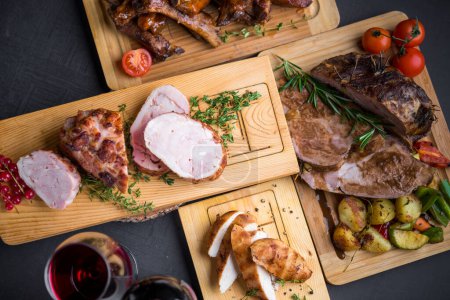 Photo for Grilled, baked, fried types of meat served on wooden boards with red wine - Royalty Free Image