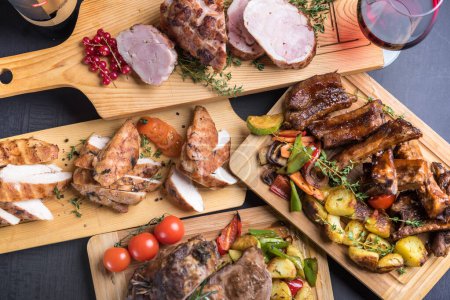 Photo for Variety of grilled, baked, fried types of meat served on wooden boards - Royalty Free Image