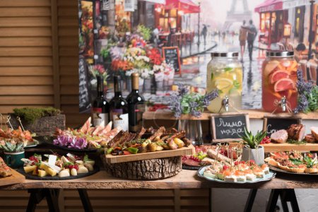 Foto de Increíble mesa de vacaciones con variedad de comida para los dedos y bebidas servidas en estilo Provenza - Imagen libre de derechos
