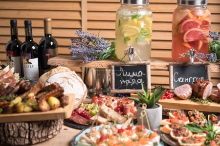 Foto de Elegante mesa de vacaciones con variedad de alimentos para los dedos y bebidas - Imagen libre de derechos