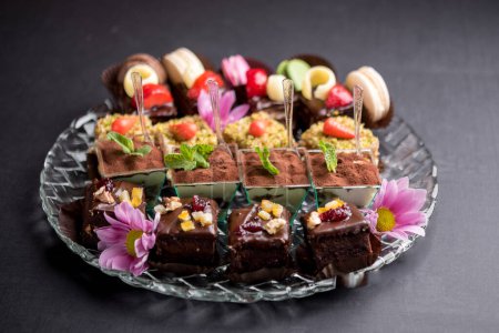Téléchargez les photos : Petits desserts élégants servis sur un plateau en verre transparent - en image libre de droit