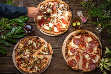 Téléchargez les photos : Vue de dessus de l'homme coupe pizza avec coupe pizza sur la table de vacances - en image libre de droit