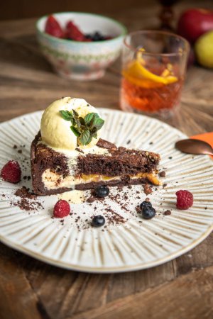 Téléchargez les photos : Gâteau au chocolat avec garniture de fruits servi avec une boule de glace - en image libre de droit