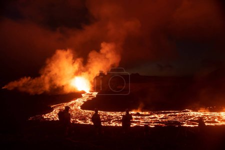 Foto de Paisaje erupción volcánica por la noche espectadores y personal de emergencia - Imagen libre de derechos