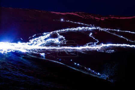 Foto de Hiker headlamps long exposure blur in volcano crater - Imagen libre de derechos
