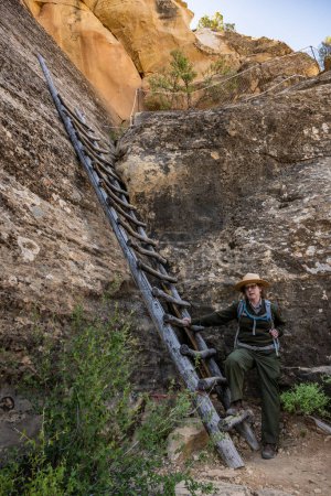 Téléchargez les photos : Parc national de Mesa Verde, États-Unis : 1 juin 2022 : Un Ranger se tient au bas d'une échelle en bois sur une falaise Visite guidée - en image libre de droit