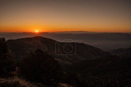 Téléchargez les photos : Orange Sunburst se lève sur les montagnes de la vallée de la mort au-dessus du bassin Badwater - en image libre de droit