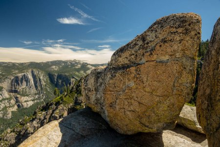Photo for Glacial Rocks Stand On The Edge Of Taft Point Overlooking Yosemite Falls In The Distance on summer day - Royalty Free Image