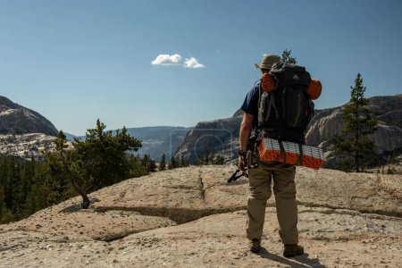 Foto de Cargado abajo Backpacker Pausas para mirar por encima del granito en el Parque Nacional de Yosemite - Imagen libre de derechos