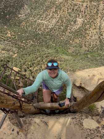 Femme monte échelle sur Balcon House Tour à Mesa Verde