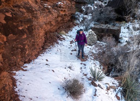 Wanderer hält auf dem verschneiten Boucher Trail im Grand Canyon inne