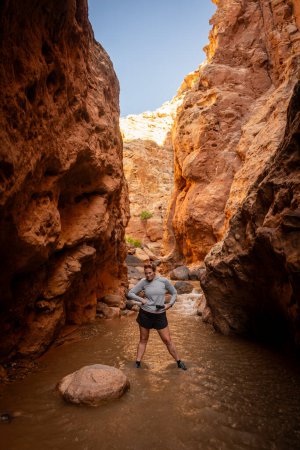 Woman Stants In Deep Canyon Creek With Her Hands On Her Hips And Makes A Funny Face in Capitol Reef