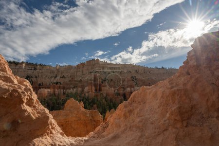 Sunbursts Over A Trail Cutting Through A Hoodoo In Bryce Canyon