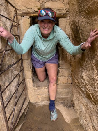 Woman Pops Out of Narrow Paseo a través de la vivienda del acantilado en Mesa Verde