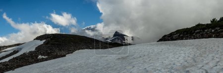 Schneeschichten und Wolken verwischen den Blick auf den Mount Rainier im Sommer