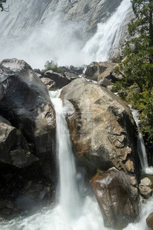 Corrientes de agua corren sobre rocas de las cataratas de Wapama en Yosemite