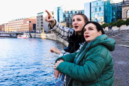 Téléchargez les photos : Deux femmes à l'automne dehors dans la ville regardant quelque chose - en image libre de droit