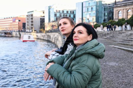 Photo for Two women in autumn outside in the city looking at something - Royalty Free Image