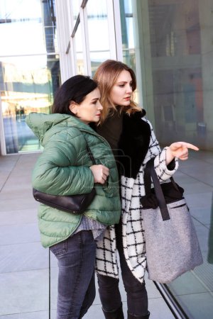 Téléchargez les photos : Deux femmes debout devant le magasin et regardant la fenêtre - en image libre de droit