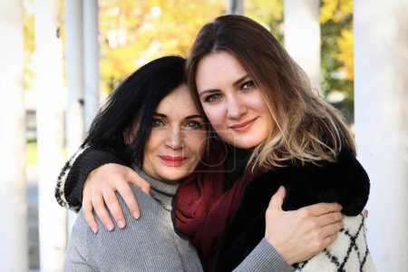 Foto de Retrato de dos mujeres en otoño afuera y abrazándose - Imagen libre de derechos
