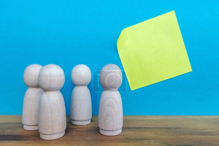 Photo for Group of wooden figures and a yellow empty note paper - Royalty Free Image