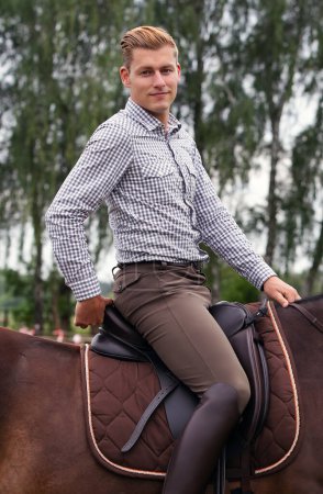 Foto de Joven guapo a caballo marrón en el campo - Imagen libre de derechos