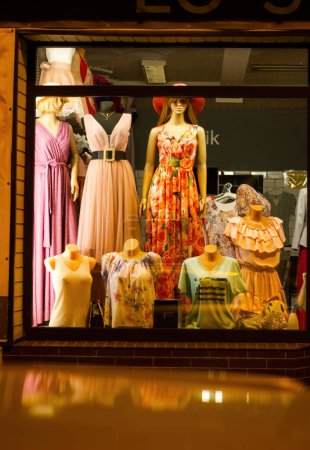 Téléchargez les photos : Lot de mannequins sans tête montrent collection de vêtements de printemps. Des mannequins debout en magasin. T-shirt orange, pantalon blanc, robe, jupe, sweat-shirt, blazer, baskets - en image libre de droit