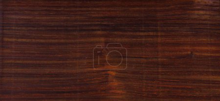 Photo for Cocobolo Dalbergia retusa is a rosewood family species. Beautiful hues of reds purples browns and a range of other dark colors. This woodgrain color chip can be used as a tileable background. - Royalty Free Image