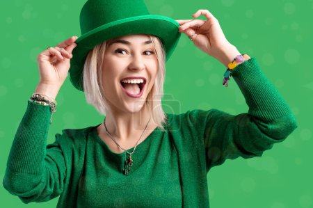 St. Patrick's Day. Schöne lächelnde Frau mit grünem Hut. Grüner Hintergrund