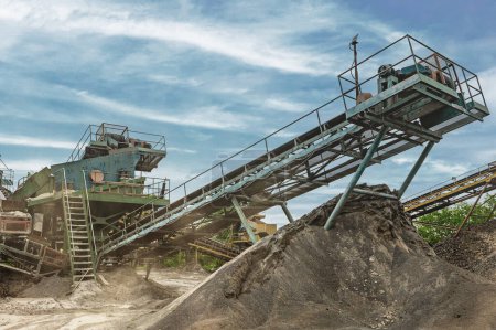 Zerkleinerungsmaschinen, Kegelbrecher, Förderung von zerkleinertem Granitkies in einem Steinbruch Tagebau Bergbau.. Bergbauindustrie Kiesgrubenförderer. 