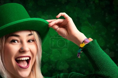 Mujer sonriente en traje verde con sombrero de duende contra un fondo de trébol
